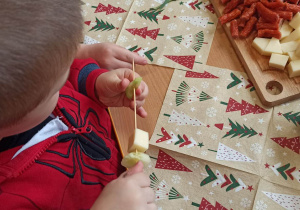 Chłopiec nakłuwa ogórek na patyk od szaszłyka.