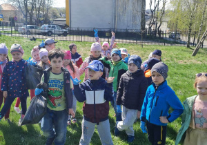 Dzieci w okolicach przedszkola pokazują ile zebrały śmieci.