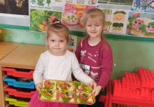 Dzieci prezentują kanapki z warzywami.