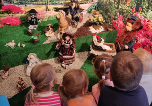 Dzieci oglądają wystawę lalek.