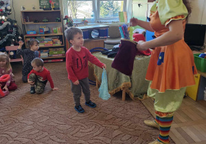 Dziecko uczestniczy w występie cyrkowca.